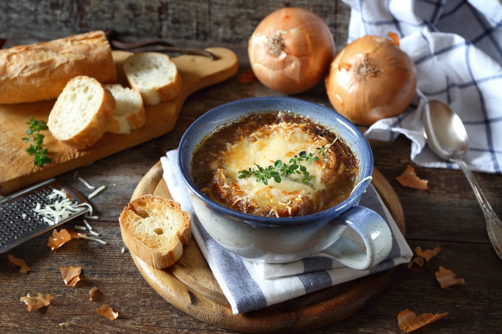 French onions soup with baguette rustic style on wooden background