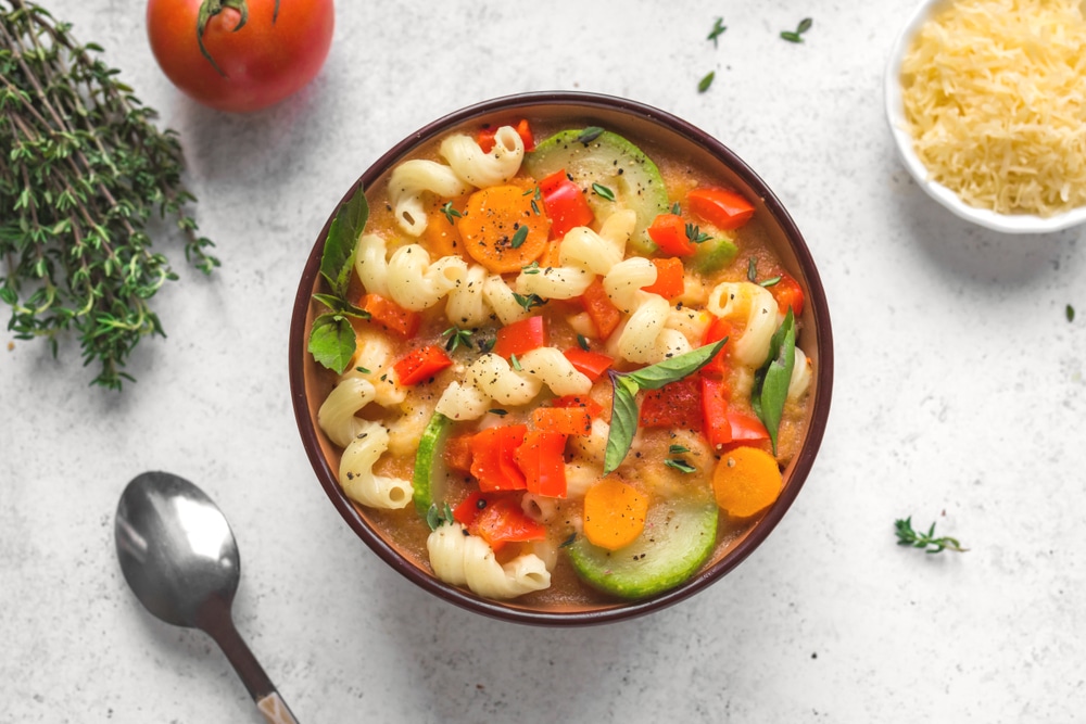  Italian vegetable soup with pasta on white background