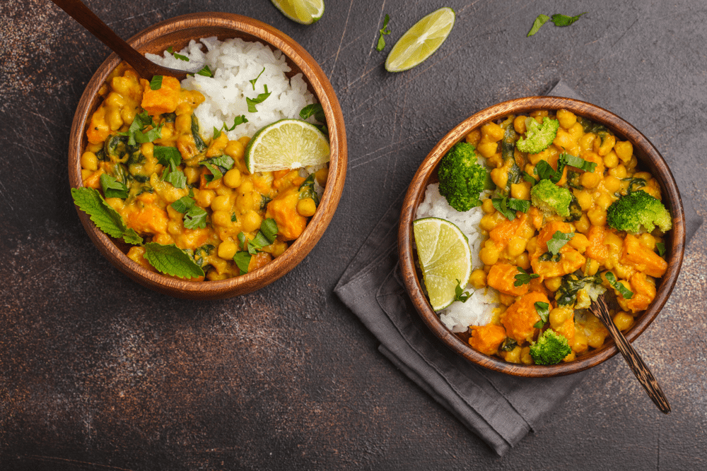 Vegan Sweet Potato Chickpea curry in wooden bowl on a dark background