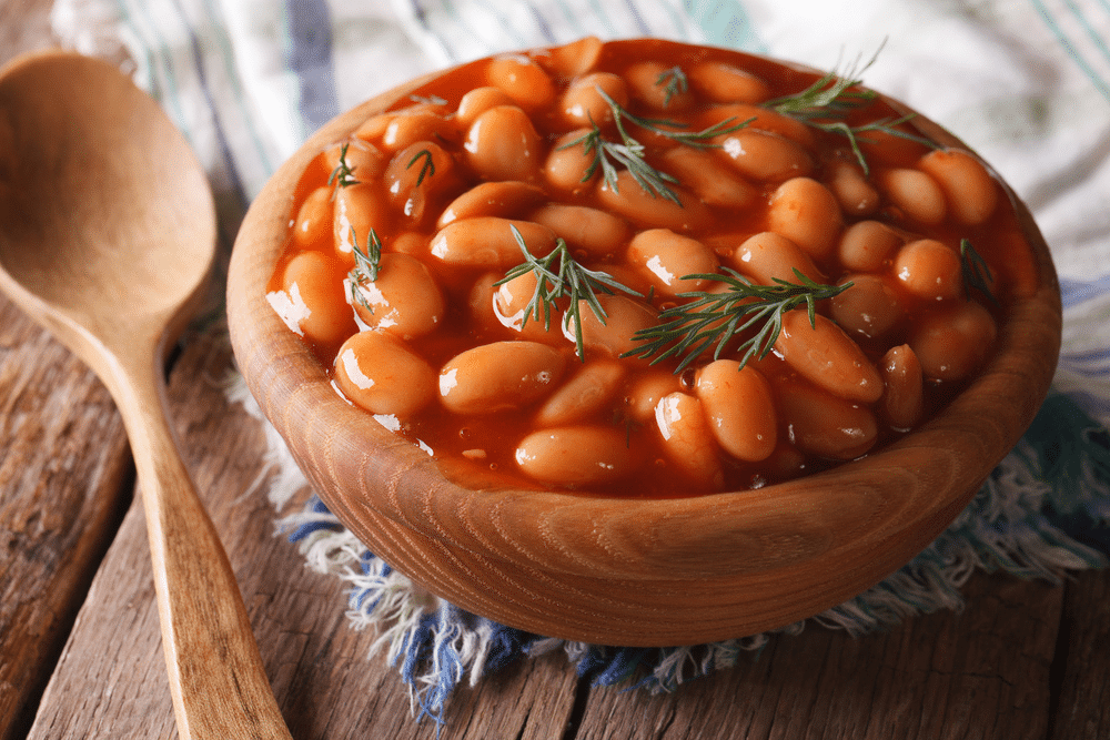 white beans in tomato sauce in a wooden bowl