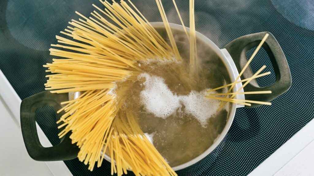 A top view of a spaghetti being boiled in a pot