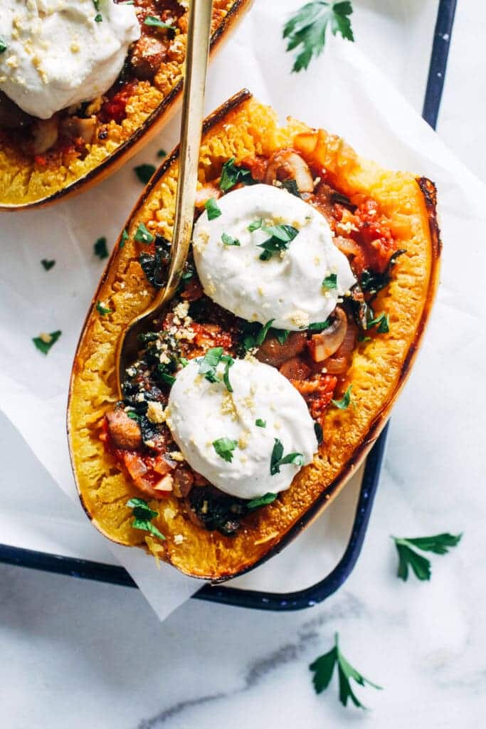 A top view of a spaghetti sqush boat with veggie fillings and ricotta cheese topping