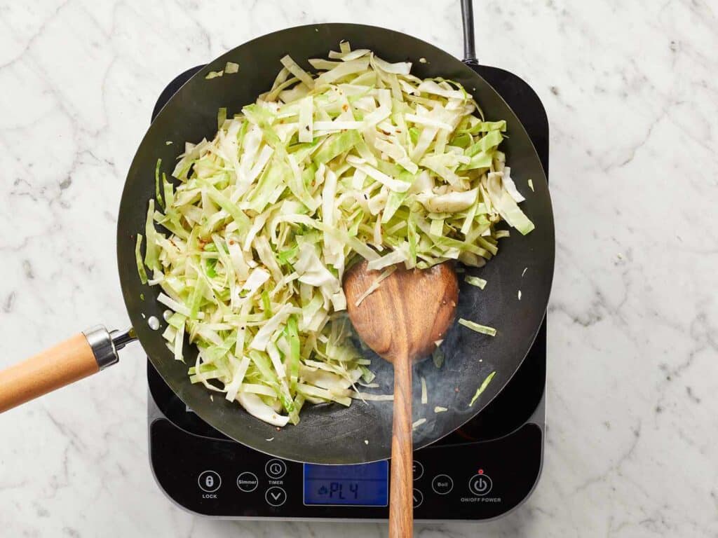 A top view of cabbage being sauteed in a pan