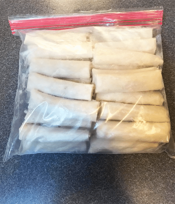 A top view of frozen egg rolls for storage in a plastic clear bag