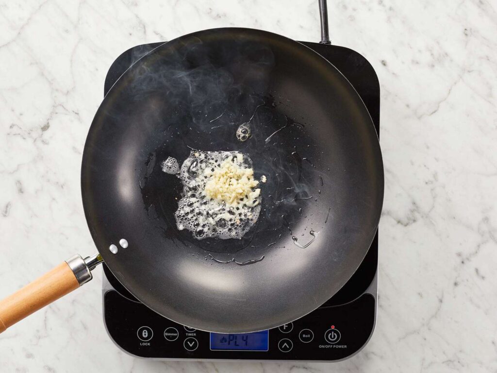 A top view of garlic being sauteed in a frying pan