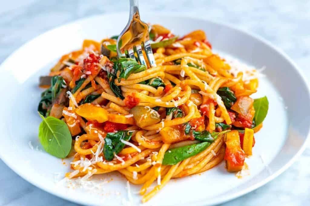 A vegetarian pasta with sauce dished out in a plate