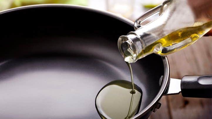 Oil being poured into a frying pan