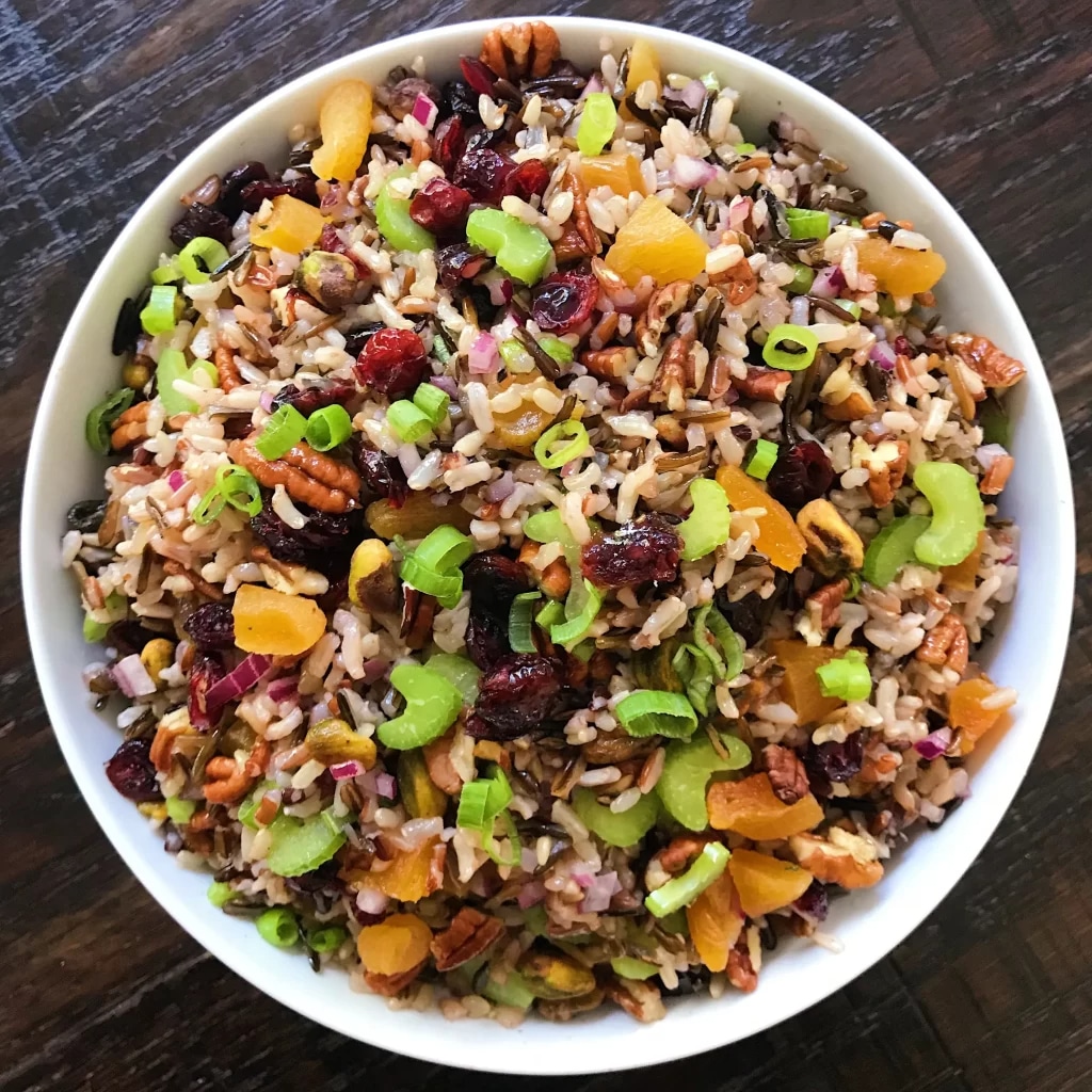 a bowl of wild rice salad with cranberries and pecans