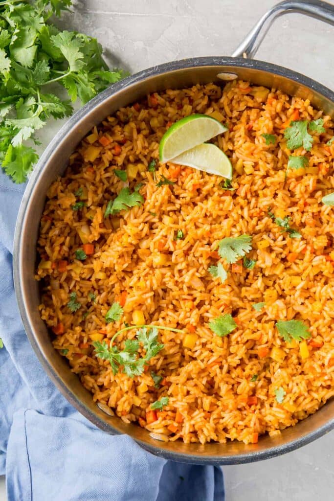 mexican rice in a skillet and garnish with lime and cilantro