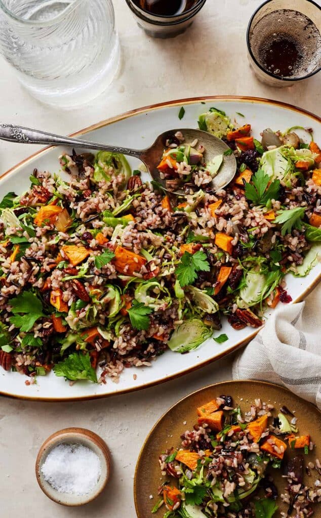 vegan wild rice pilaf in a tray along with jug of water and glass