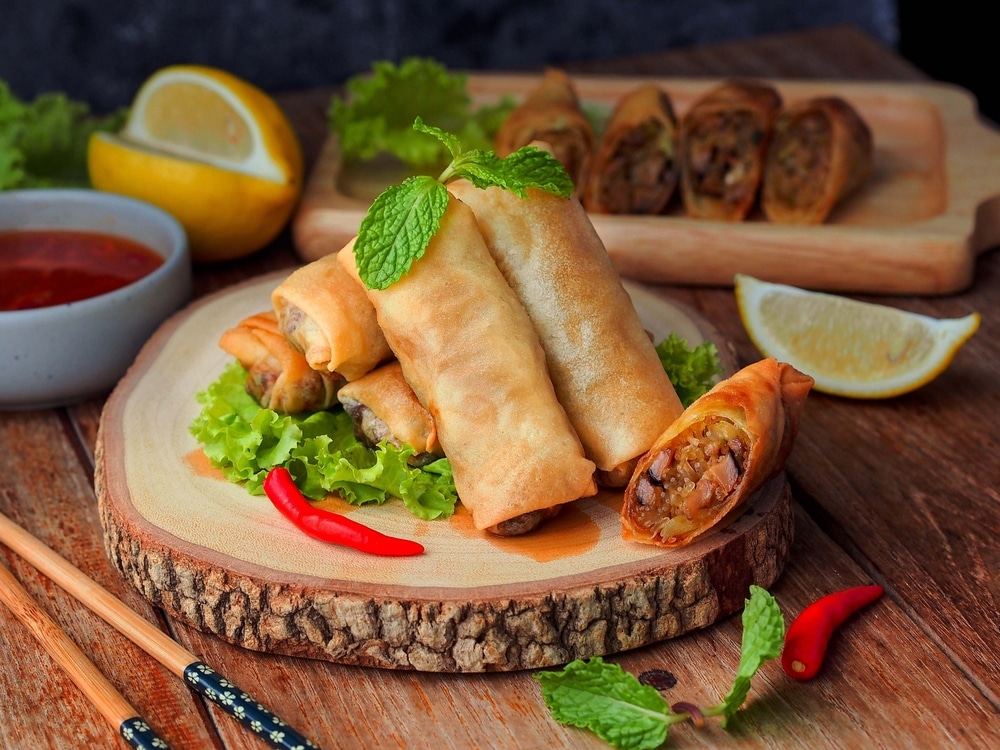 A view of fried veggie egg rolls with a mint on top