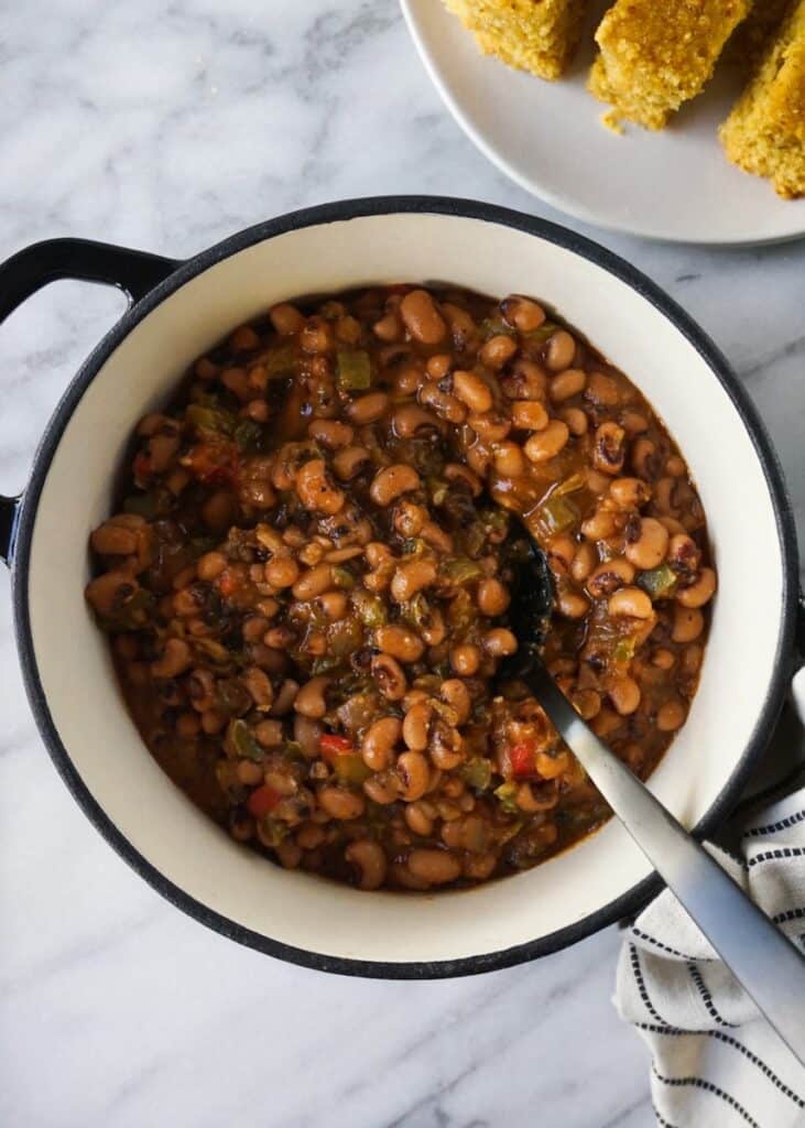 A top view of black eyes peas in a port with a spoon inside