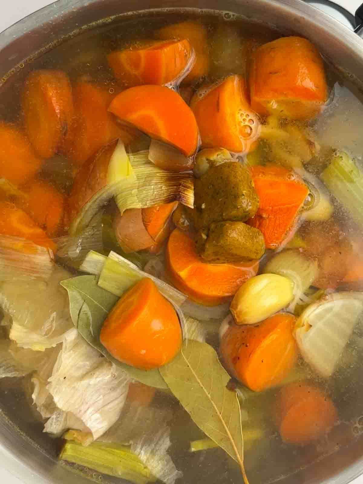 A top view of vegetables being boiled for the gravy