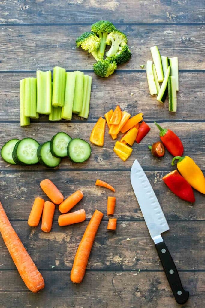 A top view of veggies cut for fajita with a knife placed