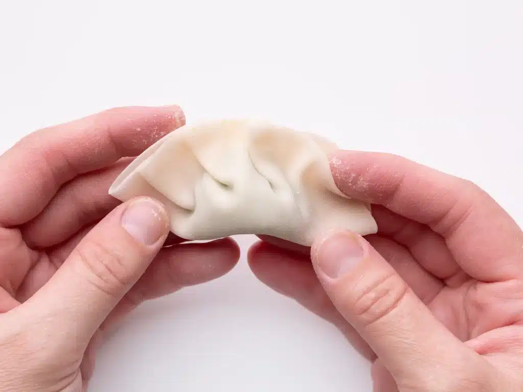 A view of a person wrapping the dumplings