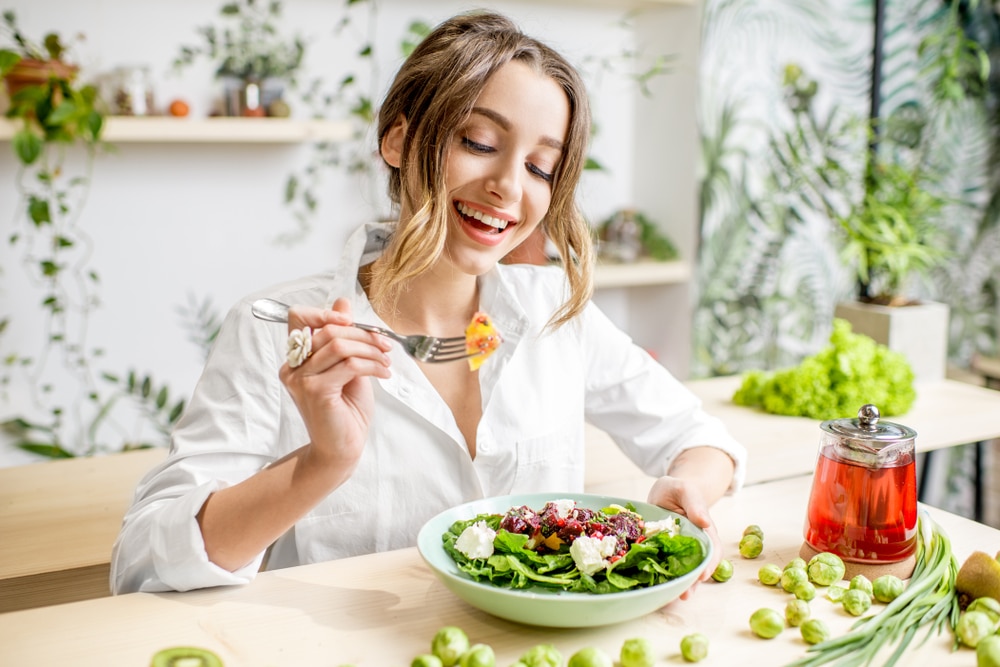 A view of a woman eating a salad bowl