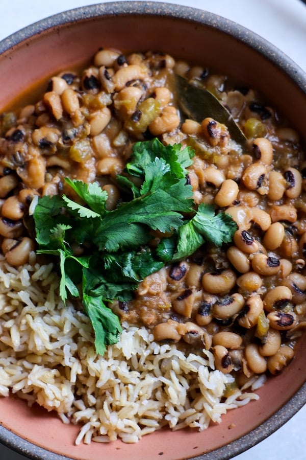 A view of black eyes peas dish served with rice topped with cilantro