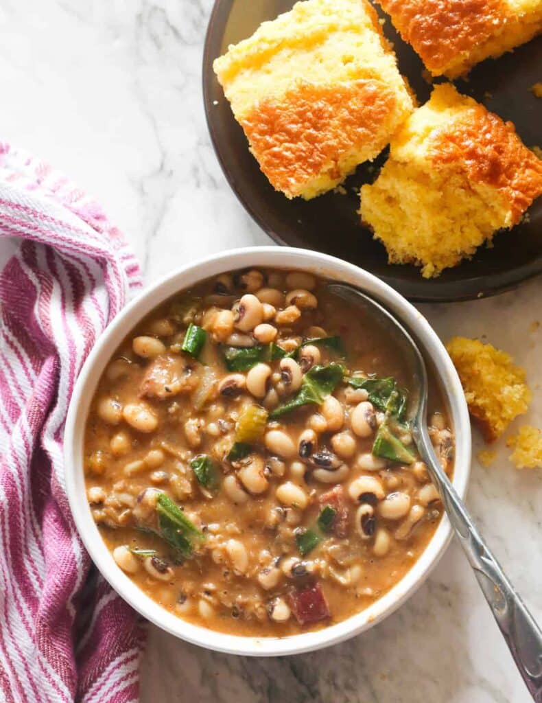 An overhead view of black eyes beans recipe served with bread