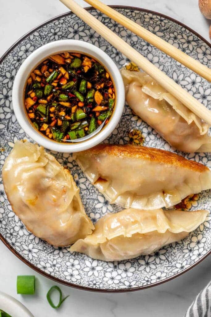 An overhead view of veggie dumplings served with sauce