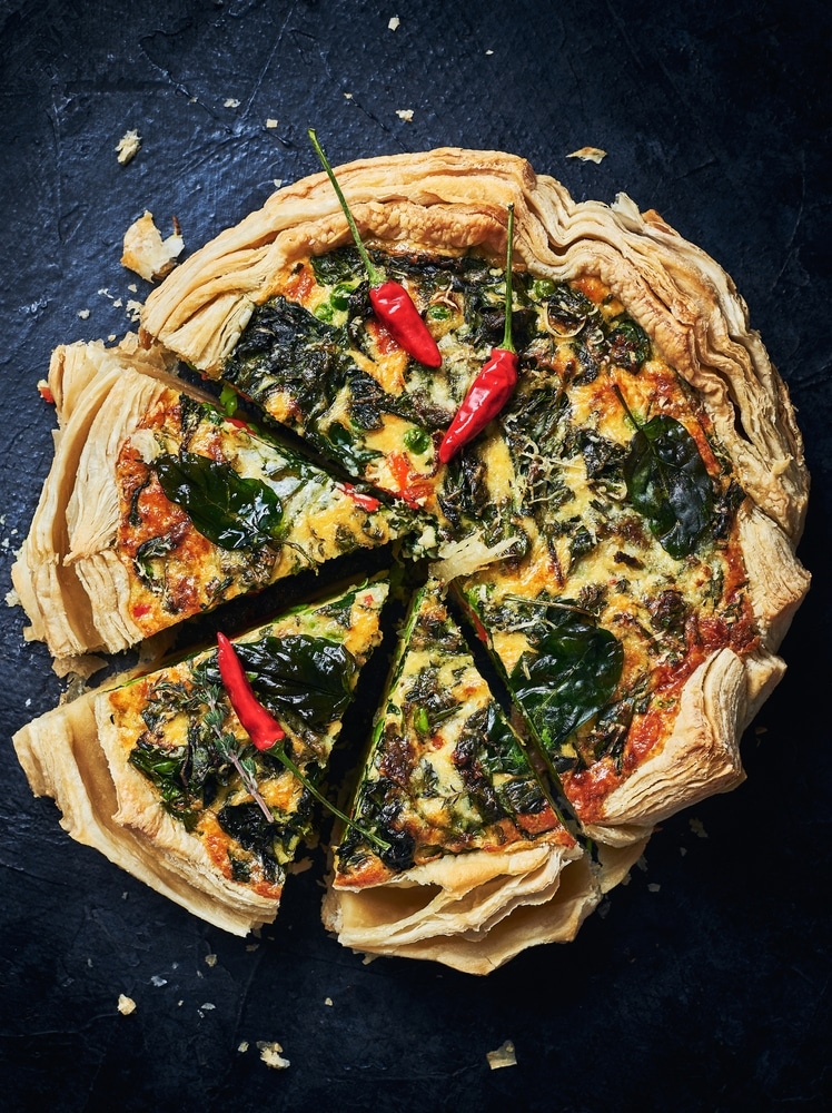 A top view of a savory quiche with veggies