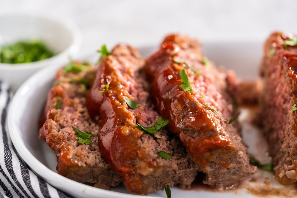 A view of meatloaf with garnish on it