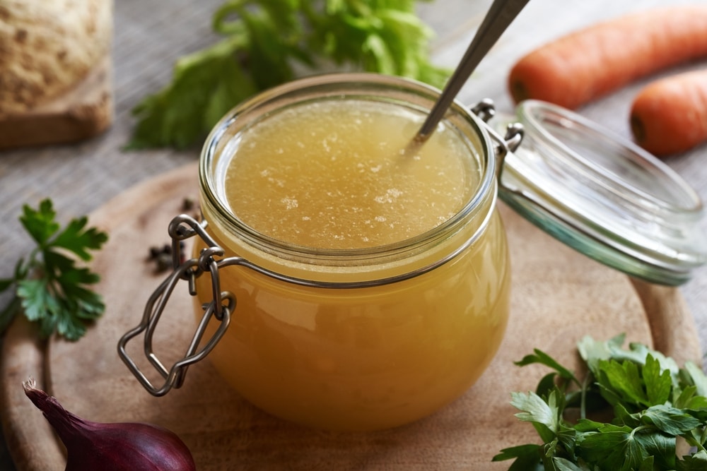 A view of some broth inside a glass jar