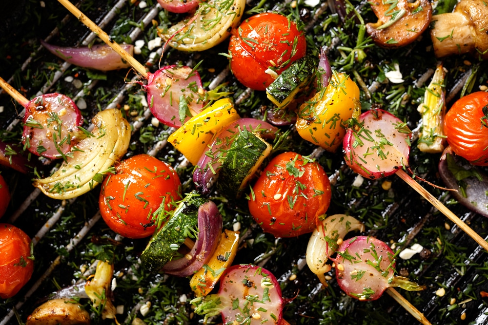 An overhead view of vegetables on a skewer grill